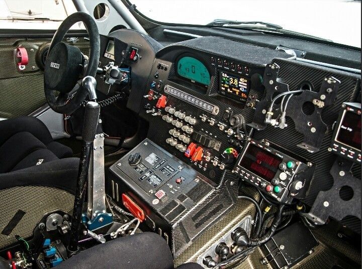 Avancerad rallybilscockpit med ratt, reglage och digitala instrument